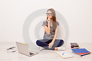 Attractive minded female student in striped t-shirt and jeans si