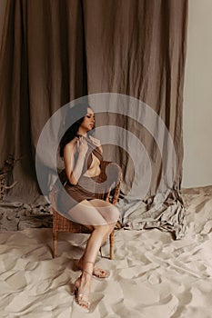 Attractive model posing in studio with sea sand.
