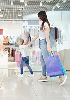 Attractive mother shopping with little daughter in mall