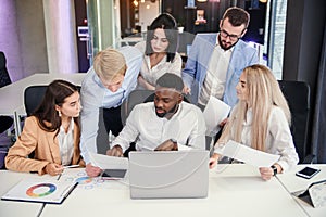 Attractive multiracial office managers discussing their business plan on the personal computer and analyse issues.