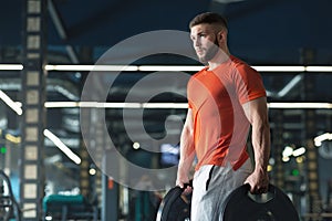 Attractive muscular bodybuilder doing heavy deadlifts in modern fitness center