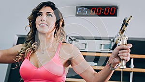 Attractive muscular fitness woman doing hard exercise in modern gym
