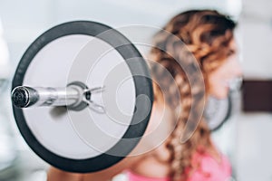 Attractive muscular fitness woman raising weight in the gym