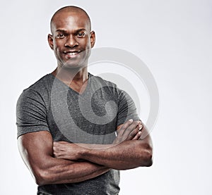 Attractive muscular happy man with folded arms