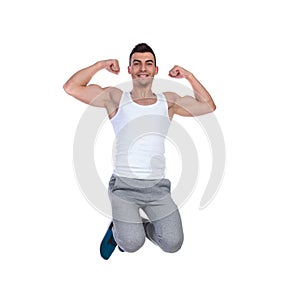 Attractive muscular man jumping and flexing his biceps