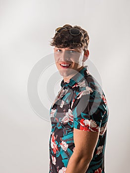 Attractive, muscular young man smiling, wearing open hawaian style shirt