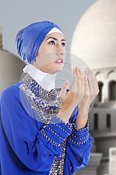 Attractive muslim girl praying at mosque