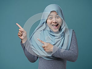 Attractive Muslim Woman Smiling and  Pointing to The Side