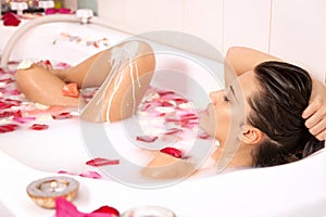 Attractive naked girl enjoys a bath with milk photo