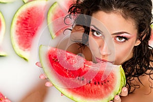 Girl enjoys a bath with milk and watermelon.