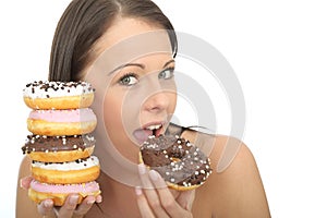 Attractive Natural Happy Young Woman Eating a Pile of Iced Donuts