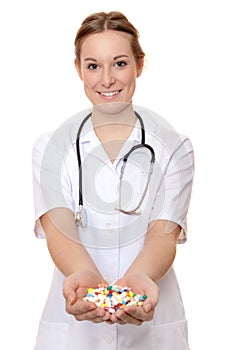 Attractive nurse with hands full of pharmaceuticals