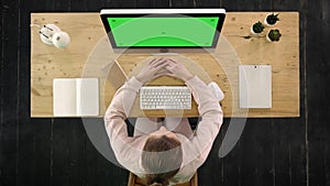 Attractive office female worker sitting at desk and working. Green Screen Mock-up Display.