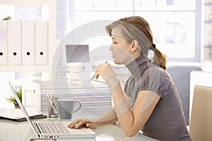 Attractive office worker sitting at desk