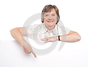 Attractive old woman indicating towards billboard photo