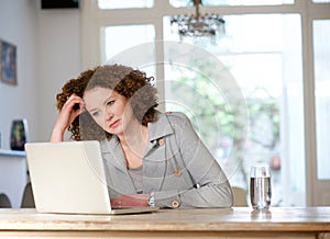 Attractive older woman looking at laptop at home