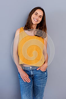 Attractive older woman smiling by gray wall