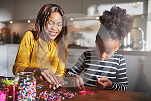 Attractive parent helping child with bead project