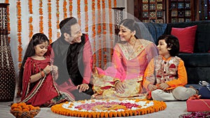 Attractive parents happily enjoying Diwali holidays with their children at home