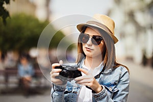 Attractive photographer woman tourist using camera outdoors in new city photo