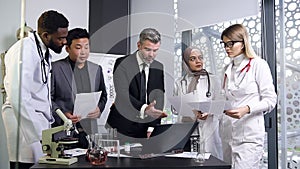 Attractive picture of group of good-looking multiracial medical people which discussing the actual medicine problems in