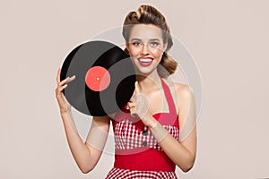 Attractive pin-up girl holding vinyl record in her hands