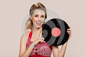 Attractive pin-up girl holding vinyl record in her hands