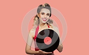 Attractive pin-up girl holding a vinyl record in her hands.