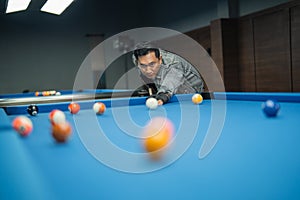 attractive pool player pooking the white ball while starting the game