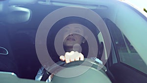 Attractive positive smiling brunette woman inside the car driving spinning steering wheel looking on road. Caucasian