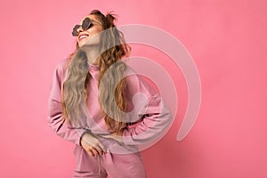 Attractive positive young blonde woman wearing everyday stylish clothes and modern sunglasses isolated on colorful