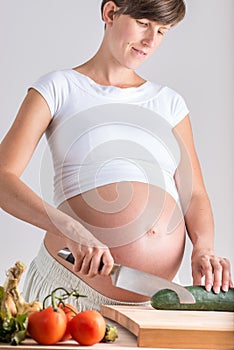 Attractive pregnant woman making a healthy salad