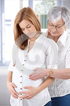 Attractive pregnant woman and senior mother