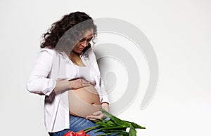 Attractive pregnant woman touching belly, isolated white background. Body positivity Pregnancy Maternity Expecting baby