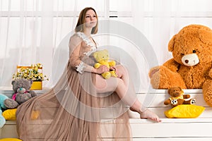 Attractive pregnant woman with toy in hands