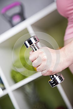 Attractive pregnant woman using a dumbbell while training