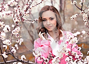 Attractive,pretty,awesome,nice girl stand in blossoming garden with white,rose flowers in spring.Cute girl with wavy,curly hair