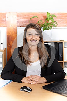 Attractive pretty young businesswoman sitting in front of laptop managing business