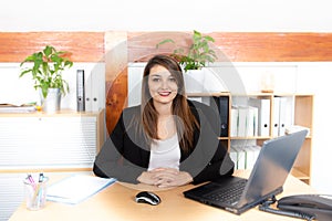 Attractive pretty young businesswoman working with laptop in her workstation