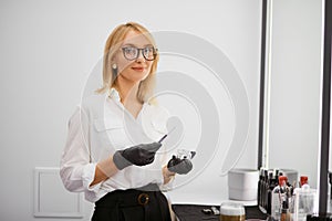 Attractive professional make-up artist preparing to do her daily work in saloon