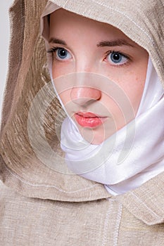 Attractive pure girl with a clear look in a white scarf addresses prayer to God