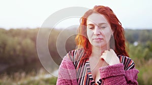 Attractive red haired young woman posing in field at sunset. slow motion. 3840x2160