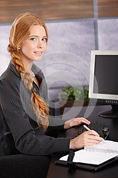 Attractive redhead businesswoman at work