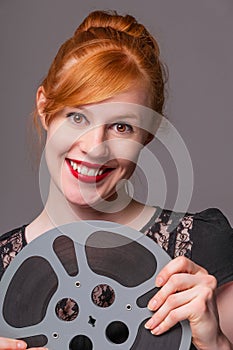 Attractive redhead holding film reel