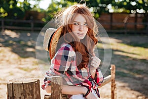 Attractive redhead young woman cowgirl standing outdoors