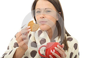 Attractive Relaxed Cosy Happy Young Woman Eating Biscuits with Tea
