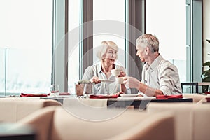 Attractive retired couple having breakfast in a cafe together