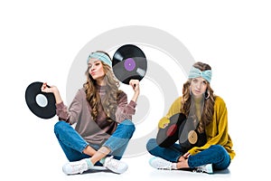 attractive retro styled young twins sitting with 12 inch vinyls