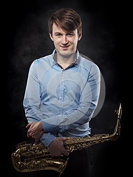 Attractive saxophonist on a dark background.