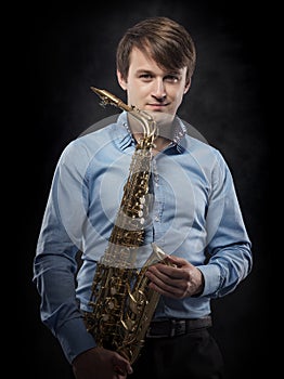 Attractive saxophonist on a dark background.